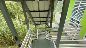 A staircase with metal railings leading to a covered area. - Perfect for large groups - House & Triplex w/private river access (Naguabo)