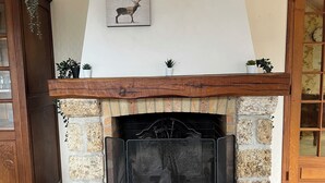 Una llar de foc amb revestiment de pedra, una biga de fusta i una obra d'art amb un cervell encadrejat a la part superior.