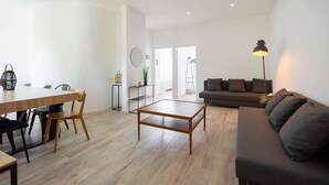 A modern living room with a wooden coffee table, a sofa, and a dining area with chairs and a table. - Maisonmars Le Concorde 3 (Marseille)