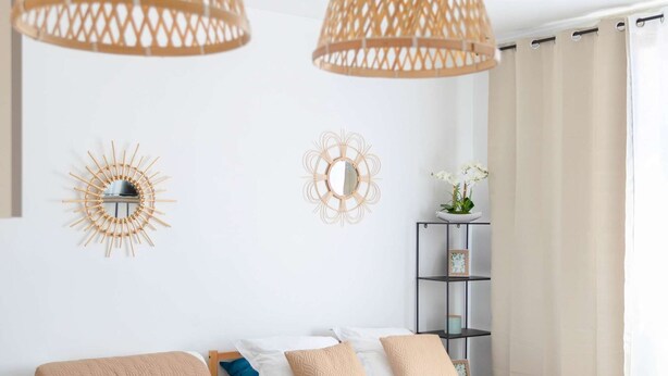 A modern hotel room with a bed, a wooden table, and two hanging rattan lamps. - Maisonmars Le Complexe Blancarde (Marseille)