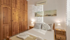 Ein Schlafzimmer mit einem großen Bett, einem Holzschrank und einem Gemälde an der Wand.
