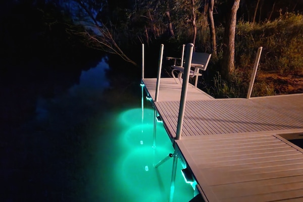 Tranquil river dock: cozy bench, gentle light.