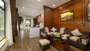 A modern living room with a sofa set, a coffee table, and a painting on the wall. - TrangTrang Classy Hotel (Hanoi)