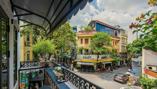 A balcony with a view of a street, including a pharmacy and a restaurant. - TrangTrang Classy Hotel (Hanoi)