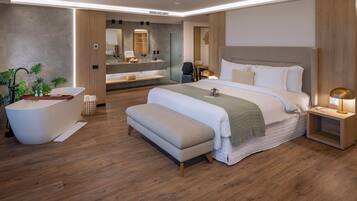 Un dormitorio de hotel moderno con una cama grande, una bañera y un tocador con espejo.