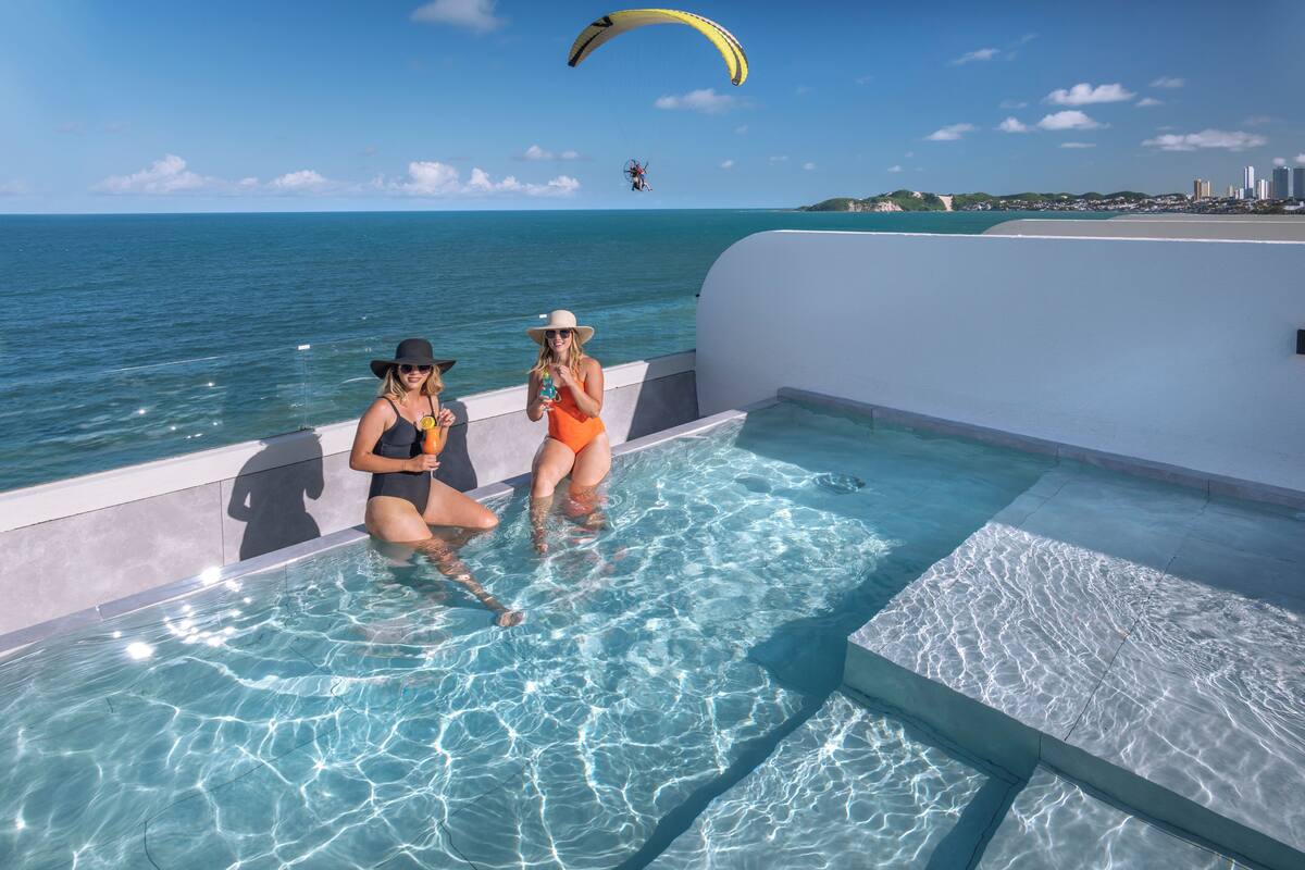 A pool with clear water and a view of the ocean.