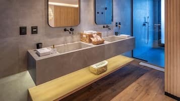 A modern bathroom with a long vanity, two sinks, and a bench.