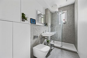 Un baño moderno con ducha, inodoro y lavabo.