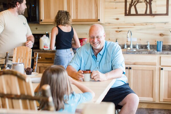 Una familia en una cocina con armarios de madera y diseño moderno.