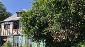 A traditional half-timbered house with a well-maintained garden, including a lawn and a variety of plants. - Maison Ancienne Avec son Jardin Privatif (Le Havre)