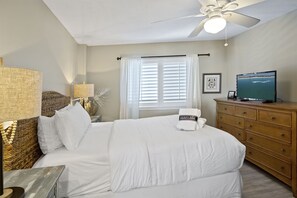 A bedroom with a bed, a wooden dresser, a television, and a ceiling fan. - Mainsail 362 - Gulf Front Condo, Community Pool, Hot Tub, Free Beach Service! (Miramar Beach)