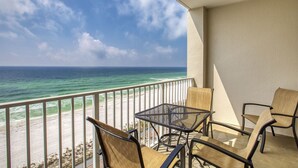 A balcony with a view of the ocean, featuring a table and two chairs. - Majestic Sun 807B - Stunning Gulf Views, Community Pool, Hot Tub, Exercise Room! (Miramar Beach)