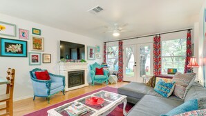 A living room with a fireplace, a sofa, a coffee table, and a blue armchair. - Contemporary Home - 1 Mi to Georgetown Square (Georgetown)