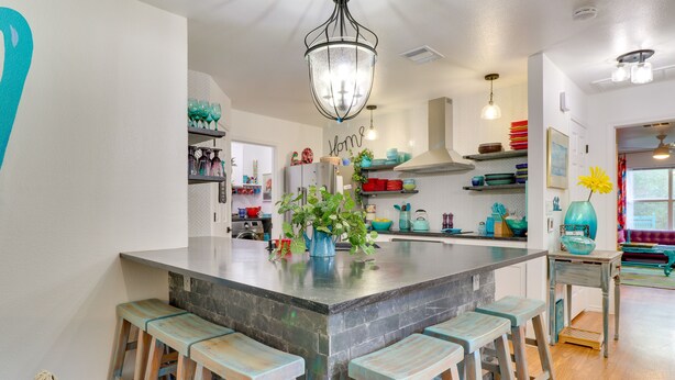 A kitchen with a large island, bar stools, a hanging light fixture, and various kitchen items on shelves. - Contemporary Home - 1 Mi to Georgetown Square (Georgetown)