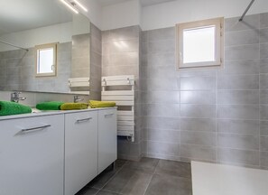 Bathroom features a large mirror above a vanity with two drawers and a countertop.