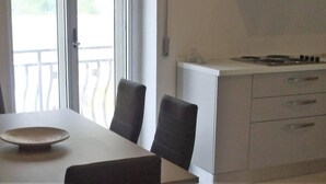 Una cocina con una mesa y sillas, estufa y vistas al exterior.