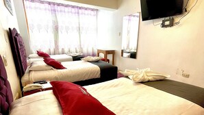 A hotel room with three beds, a TV, and a telephone. - Hotel Feimar (Cusco)