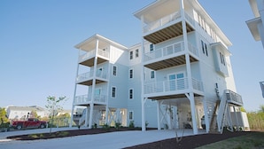 A multi-story residential building with balconies and a staircase leading to the upper levels. - Lakefront Oasis w/ panoramic views on private road (Carolina Beach)