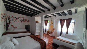 A room with two beds, a sofa, a hammock, and a window with curtains. - VILLA LUISA HOTELS (Sáchica)