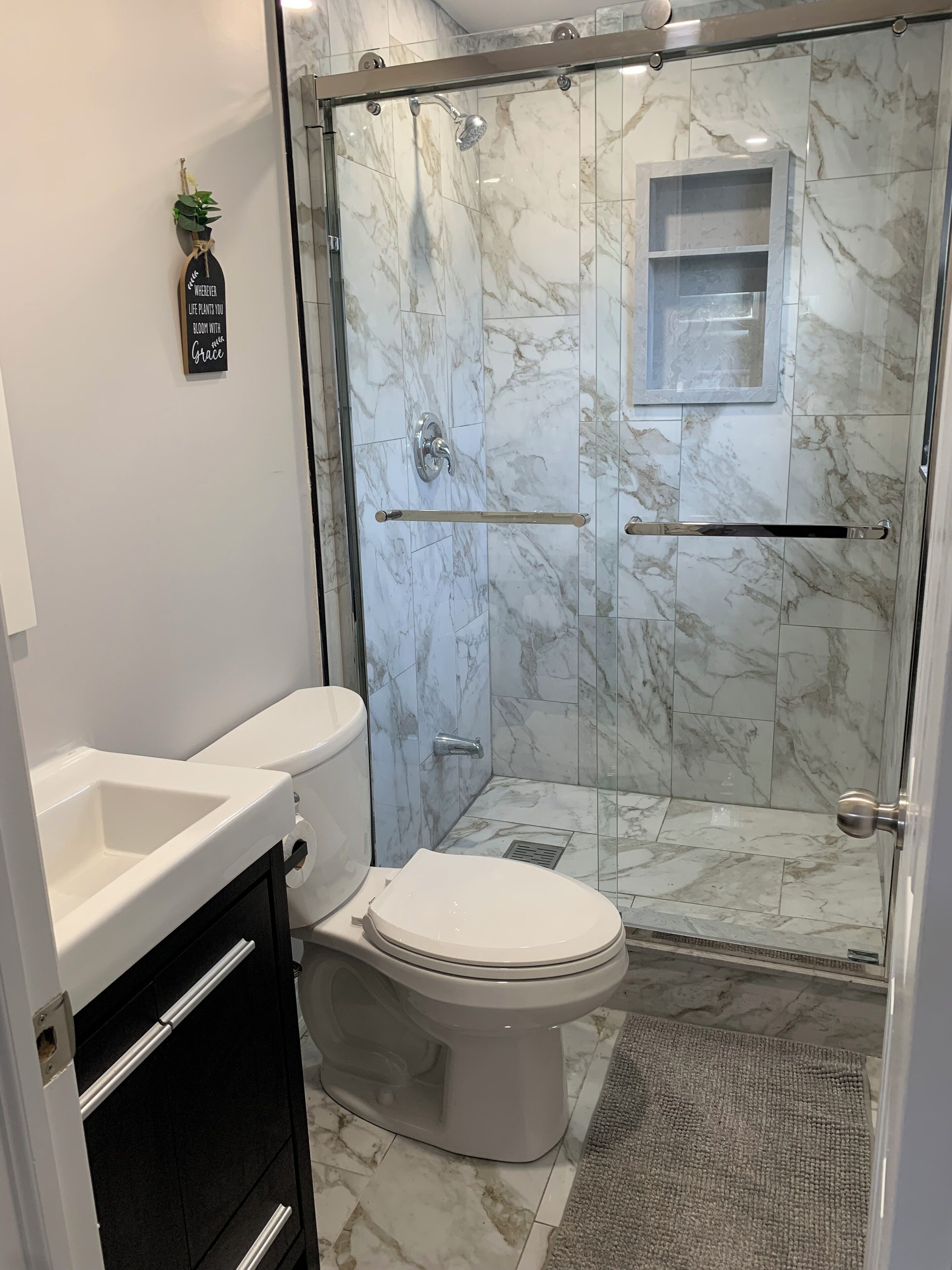 Un baño moderno con ducha de vidrio, inodoro y lavamanos.