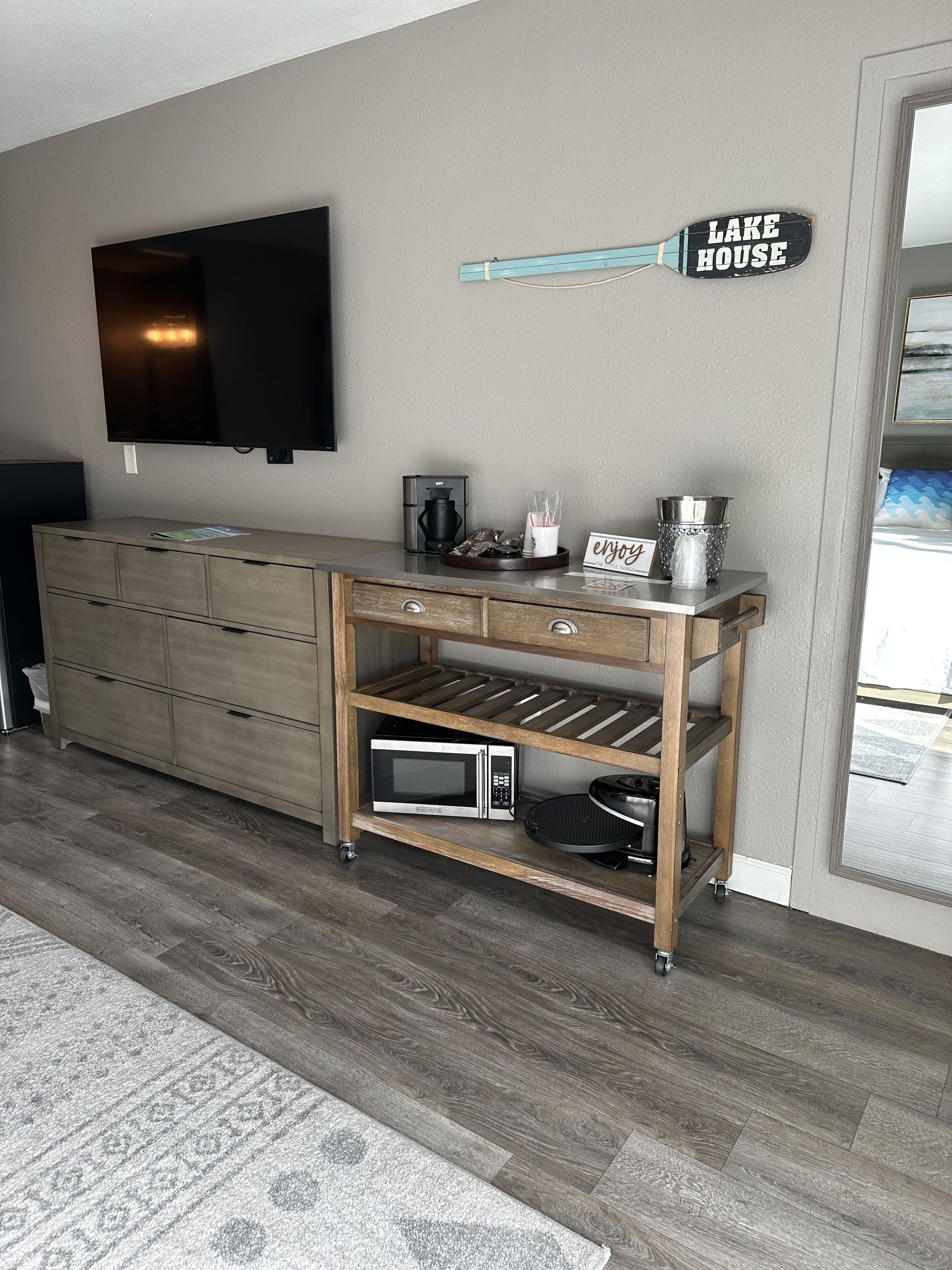 A modern kitchen with a built-in microwave, a coffee maker, and a sign that reads "LAKE HOUSE".