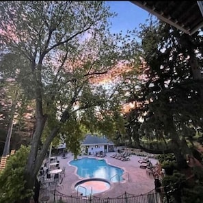 A pool area with lounge chairs and a building in the background. - Victorian Inn Elkhart Lake Wisconsin (Elkhart Lake)