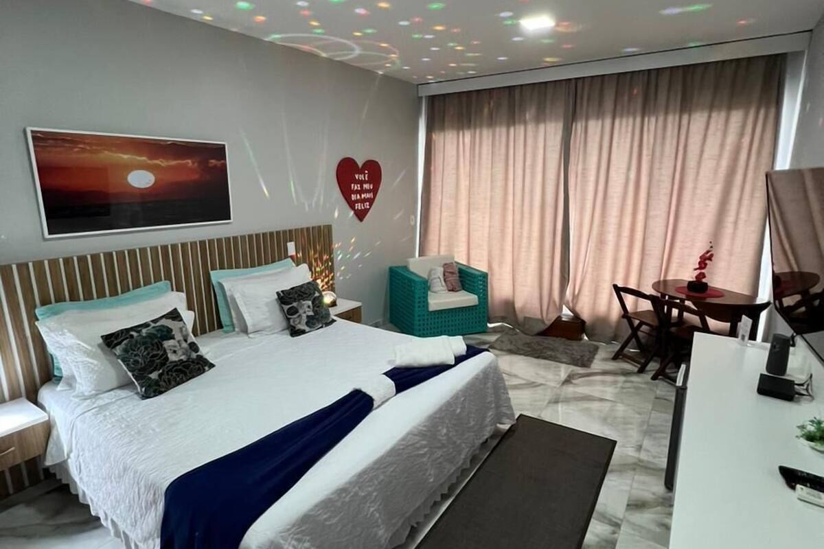 Una camera da letto moderna con un letto grande, una scrivania e un'area pranzo.