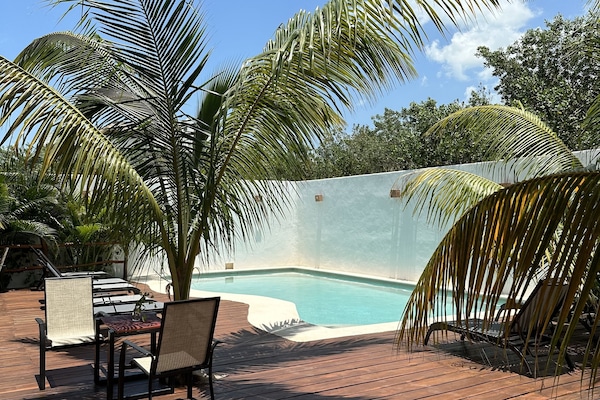 Una piscina al aire libre, sillones reclinables de piscina