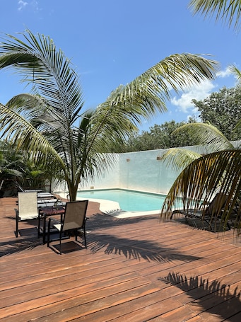 Una piscina al aire libre, sillones reclinables de piscina