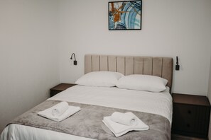 Sengetøy av topp kvalitet, dundyner, minibar og safe på rommet