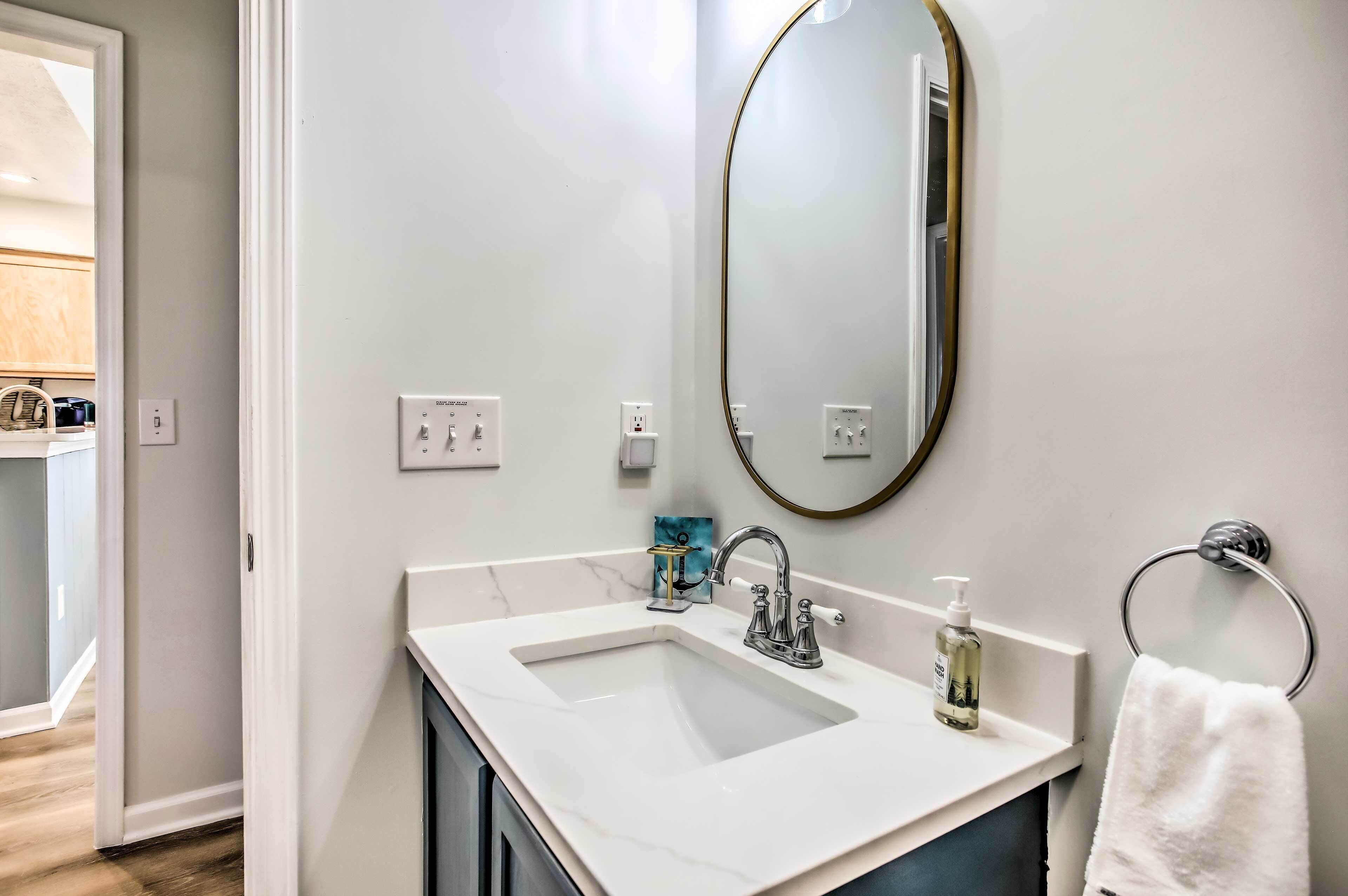 A bathroom with a white sink, a mirror, and a towel ring.