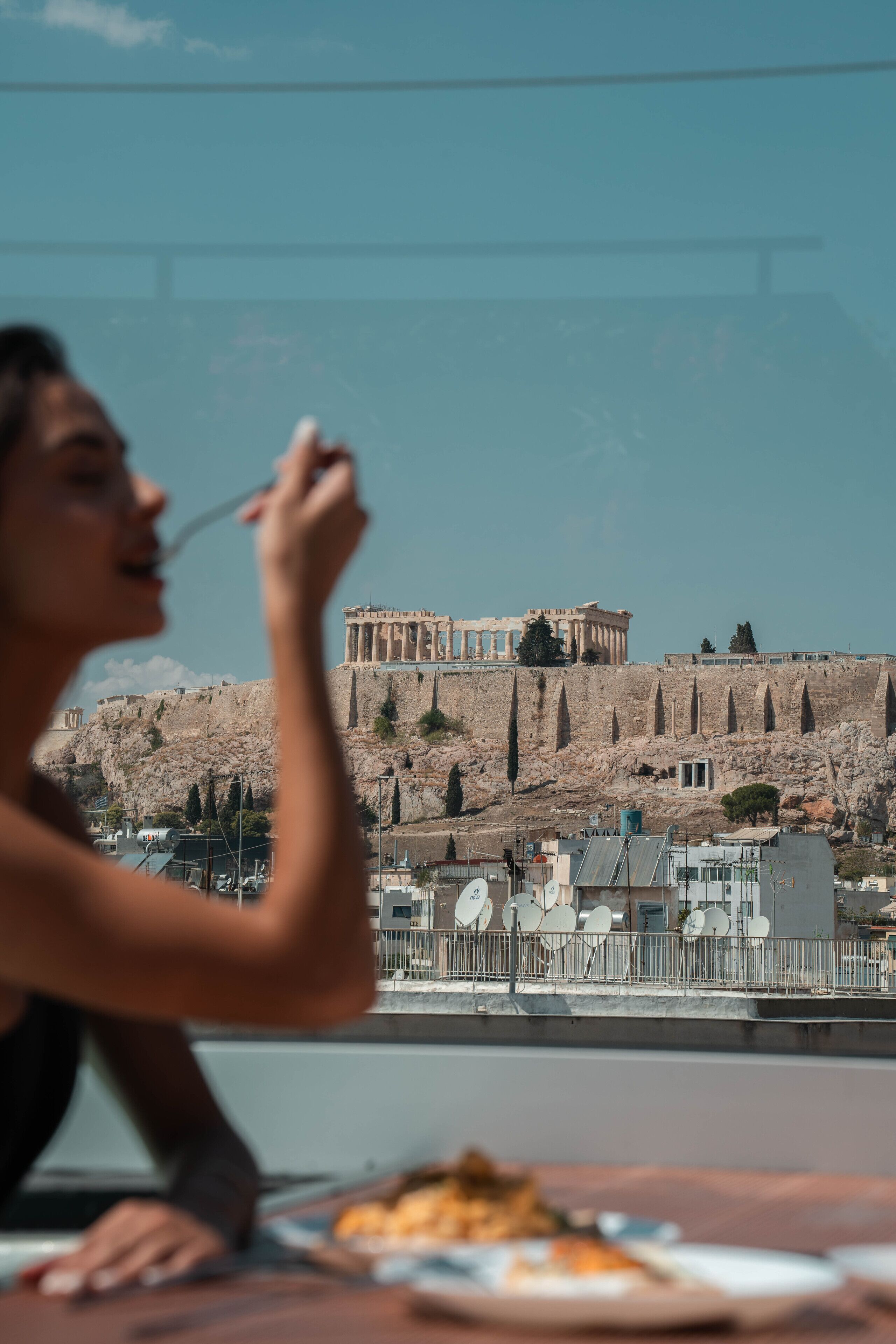 A person dining with a view of ancient ruins in the background.
