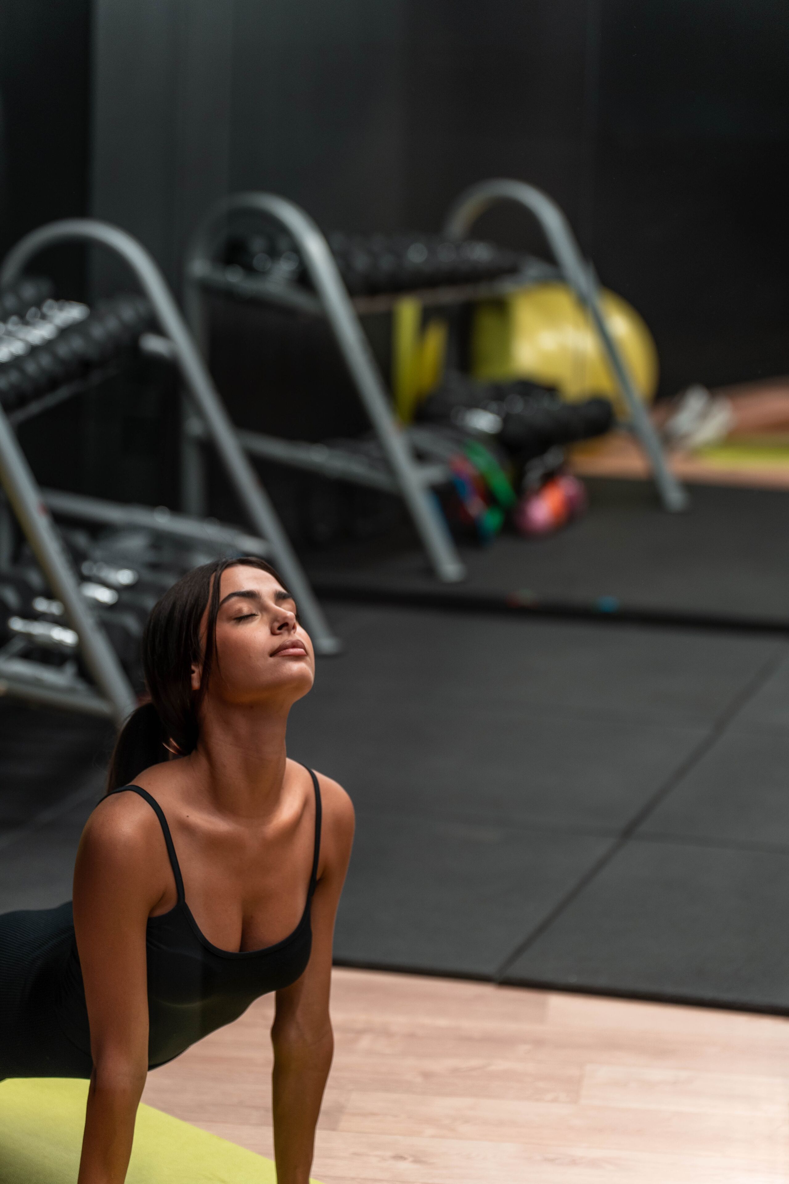 A person in a gym setting with exercise equipment in the background.