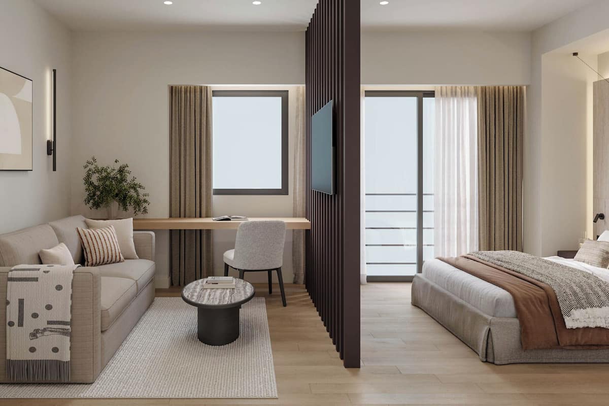 Una habitación de hotel moderna con sofá, escritorio, silla, cama y televisor.