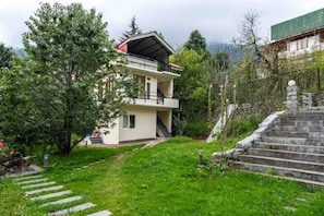 Stunning two-story residence with a flat roof, balcony, and beautifully manicured lawn.