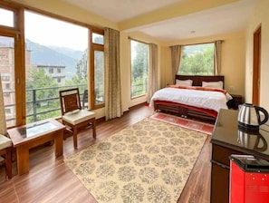 Enjoy a mountain view from the comfort of this room, featuring a large bed and a desk with a chair.