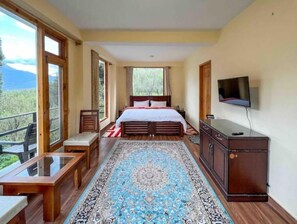 Relax in this serene bedroom with a large bed, flat-screen TV, and comfortable seating area.