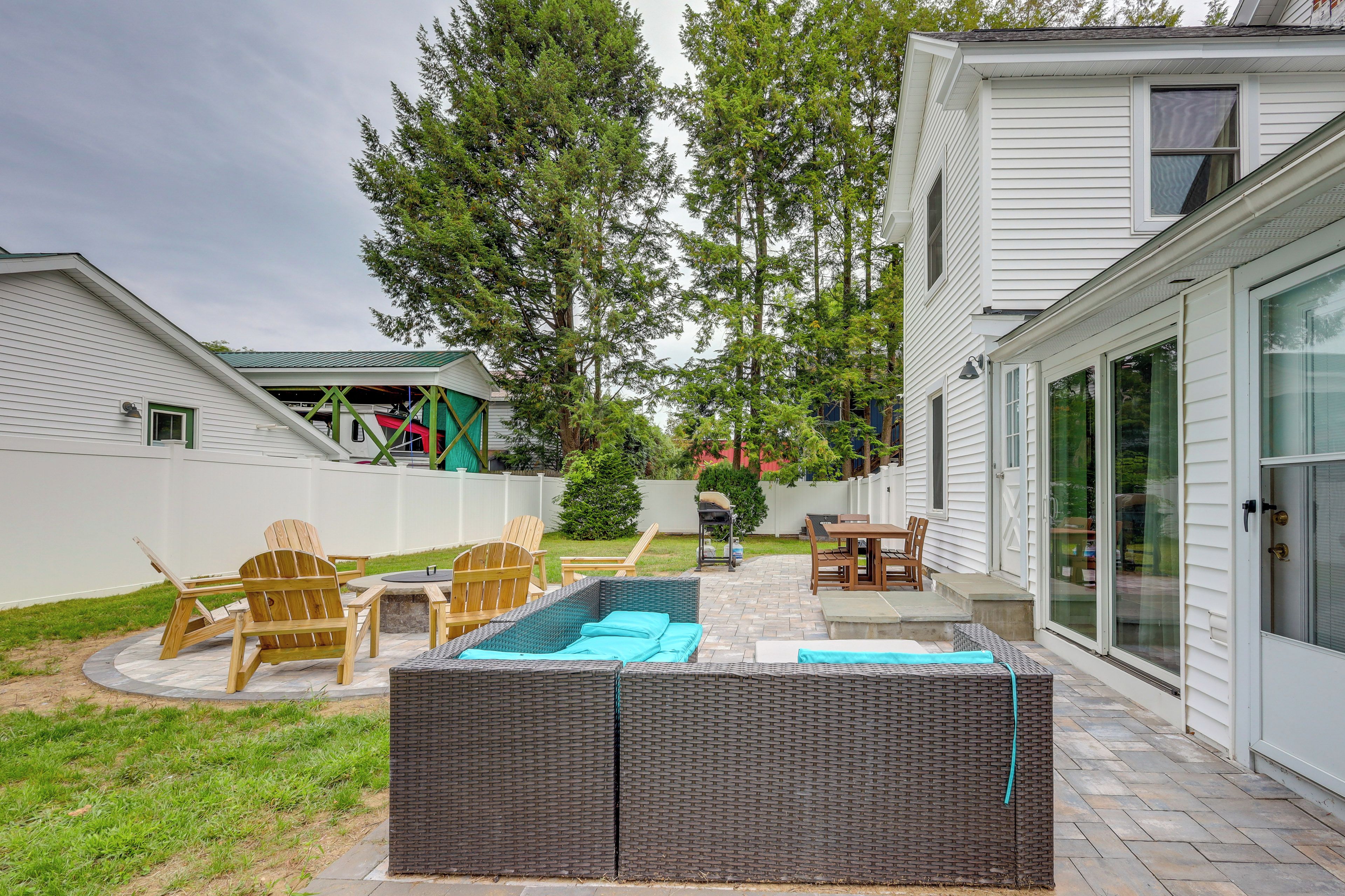 A backyard with a swimming pool, outdoor furniture, and a covered patio area.