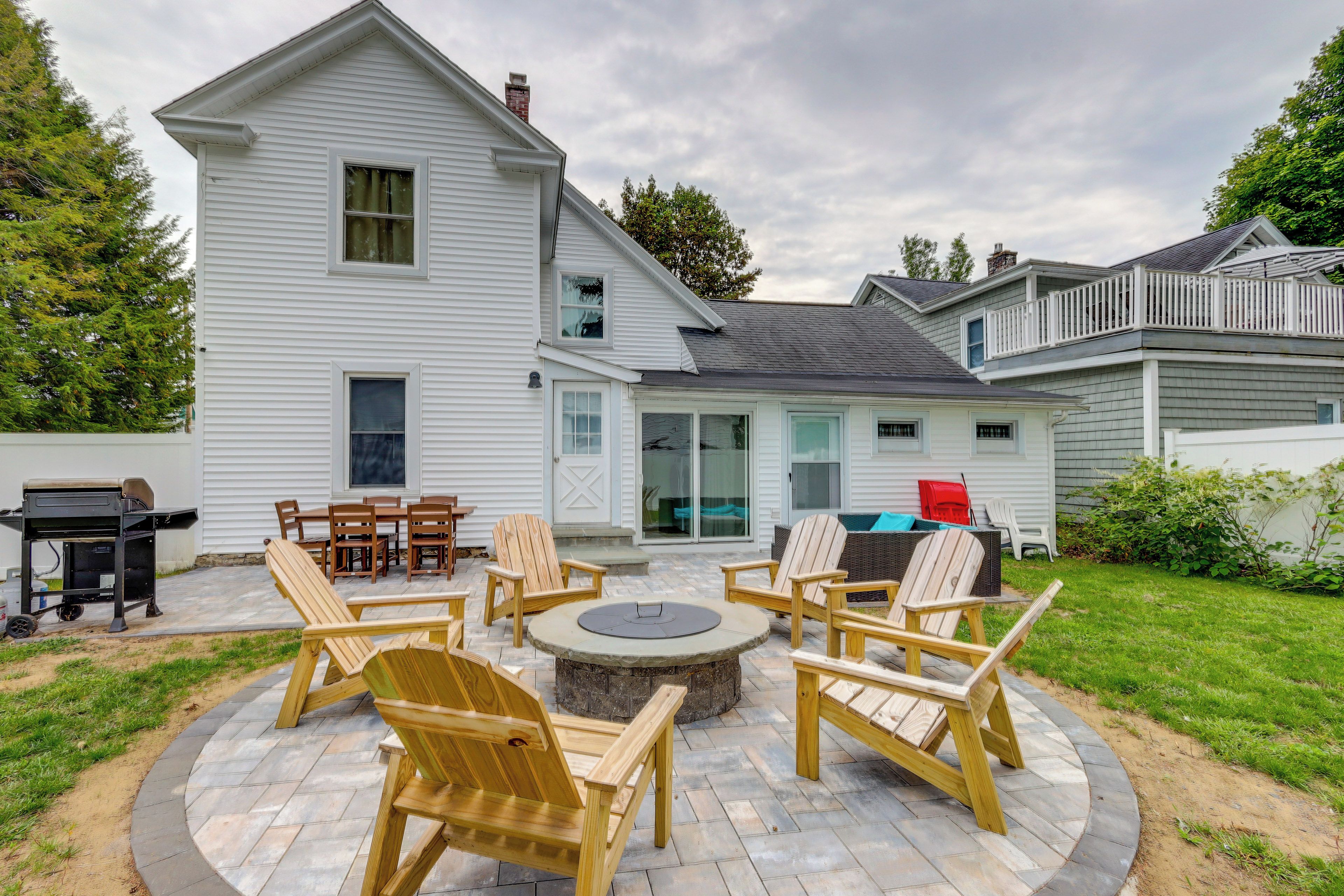 A house with a patio area featuring outdoor furniture and a fire pit.