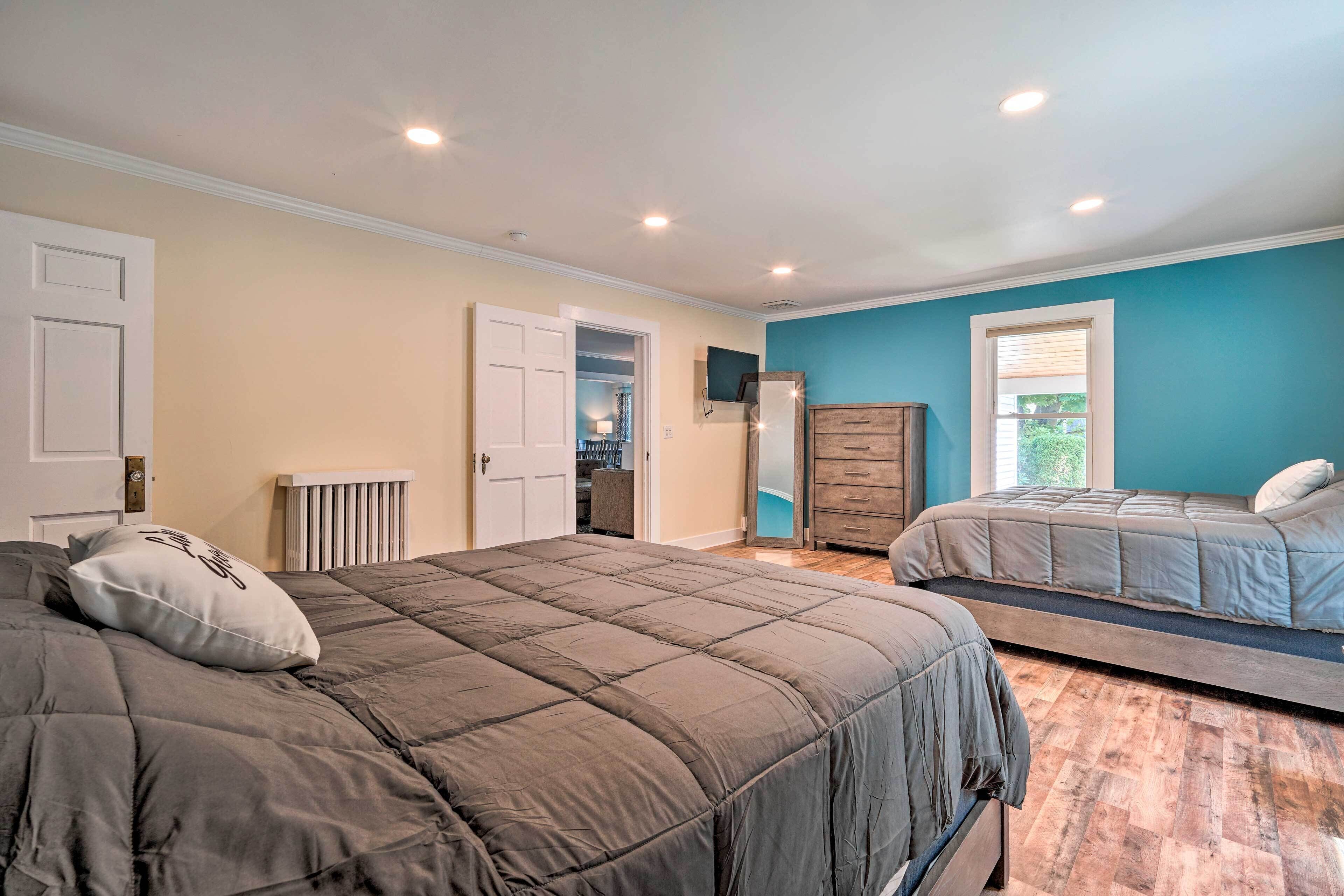 Une chambre avec deux lits, une commode et un radiateur.