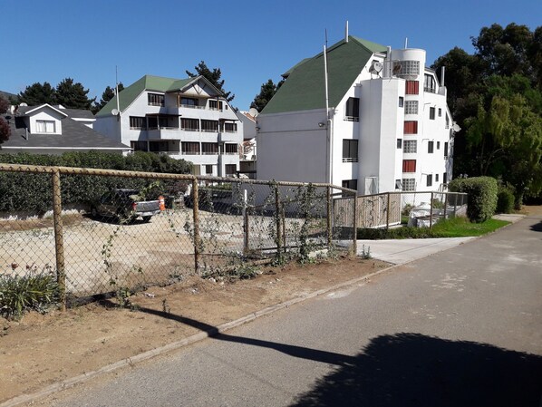 Zona residencial con casas modernas, patio cercado y una calle despejada.