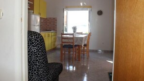 A compact kitchen with yellow cabinets, a dining table with chairs, and a window with a view. - Apartment in Sevid with Seaview, Balcony, Air condition, WIFI (5169-2) (Sevid)