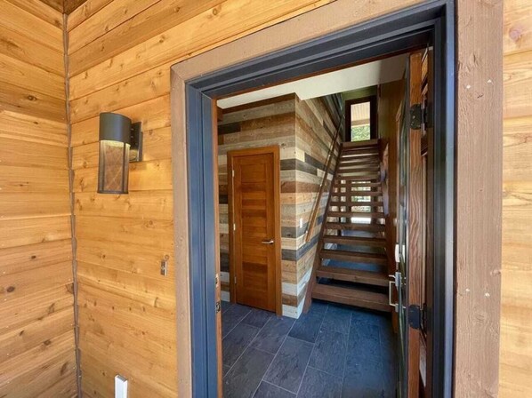 A wooden interior with a staircase leading to a door.
