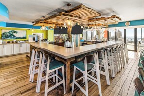 Enjoy meals in the kitchen's central dining space, surrounded by pendant lights and a balcony view.