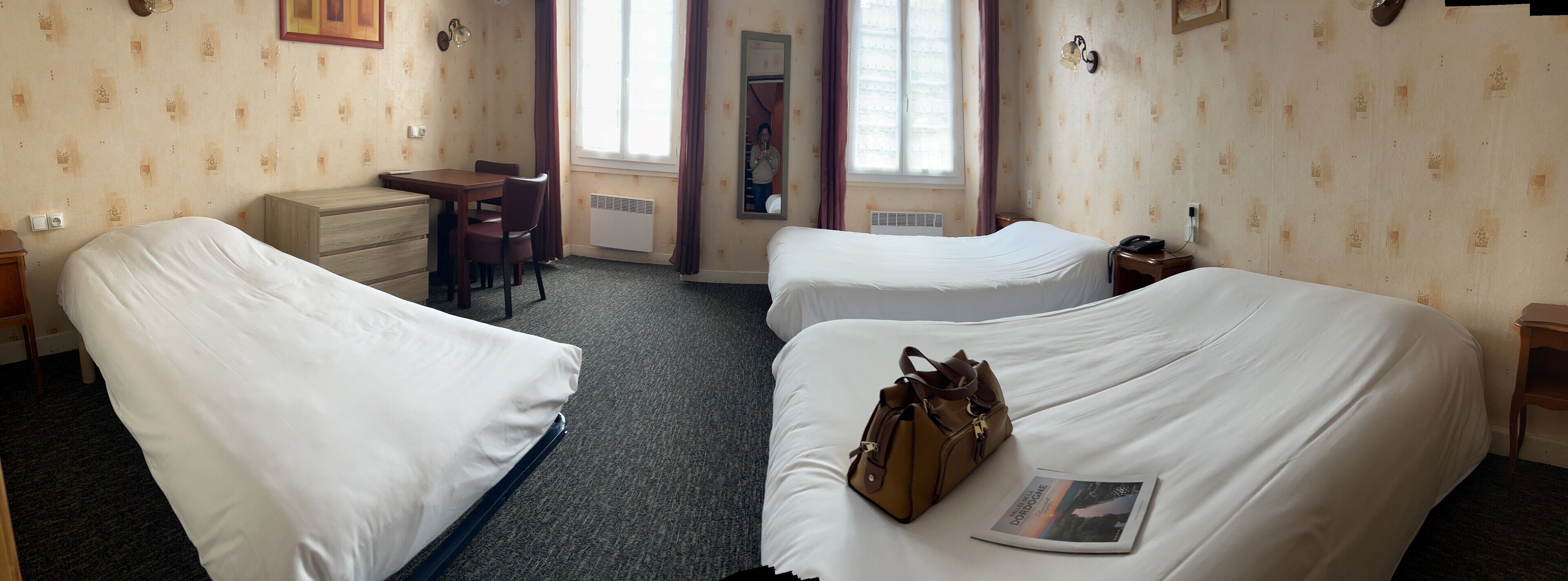 Een hotelkamer met twee bedden, een bureau en een stoel.