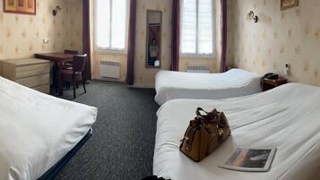 Een hotelkamer met twee bedden, een bureau en een stoel.