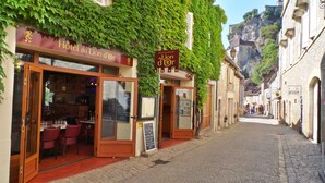 Une rue étroite où se trouve un restaurant appelé « Hôtel du Lion d’Or », et une enseigne indiquant « Restaurant du Lion d’Or » au-dessus de l’entrée.