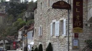 Un bâtiment en pierre avec une enseigne indiquant « Hôtel du Lion d’Or » et un espace d’accueil situé à 50 mètres.