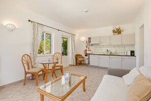 A compact living space with a dining area, kitchenette, and a sofa.