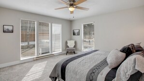 Une chambre à coucher avec un lit, une chaise et un ventilateur de plafond.